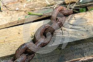 An old rusty anchor chain. Fixing the boat on the pier. Rusty iron construction