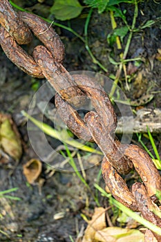 An old rusty anchor chain. Fixing the boat on the pier. Rusty iron construction