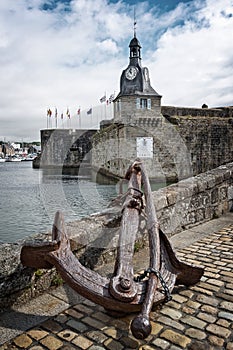 Old rusty anchor at the entrance of the closed city of Concarneau in FinistÃÂ¨re, Brittany France photo