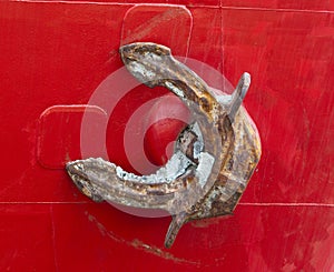 Old rusty anchor of a red freighter