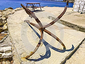 Old, rusty anchor on the seashore. at the port with ships and yachts there is an anchor. tourists can see rust at anchor. marine