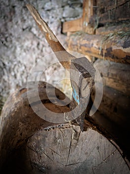 Old rusty ax stuck in a block of wood