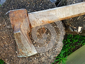 Old rusty ax on a wooden deck, top view, selective focus