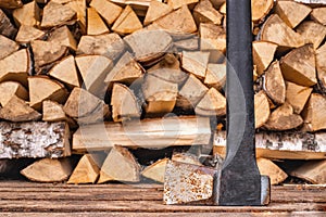 An old rusty axe stands against the woodpile