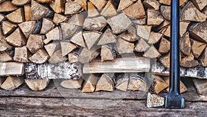 An old rusty axe stands against the woodpile