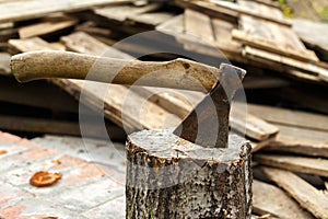 Old rusty axe stuck in a birch stump