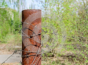 Old and rusty barbed wire on a metal pole. Ghost Town Pripyat.