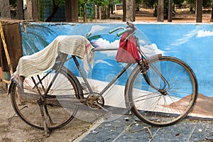 Old rusty bicycle parked against a wall