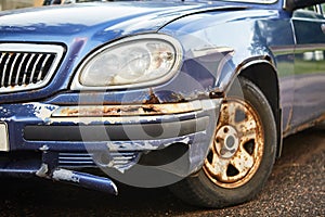 old rusty blue car, front view, sunny day