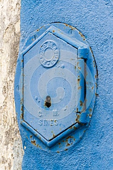 Old rusty blue painted iron lid of a valve box of the SERVICO DE AGUA PUBLIC WATER SUPPLY photo