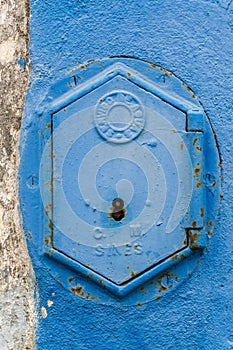 Old rusty blue painted iron lid of a valve box of the SERVICO DE AGUA PUBLIC WATER SUPPLY photo