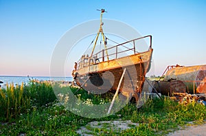 Old rusty boat at seashore with green grass