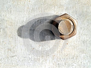 old rusty bolt and nut with long dark shadows on grunge gray steel plate under sunlight with copy space