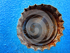 Old Rusty Bottle Cap Bottlecap on Blue Background