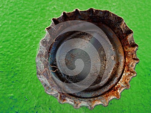 Old Rusty Bottle Cap Bottlecap on Green Background