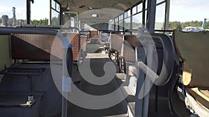 An old rusty broken cabin of an abandoned bus with damaged leather seats. CemeteryRecycling and utilization of public