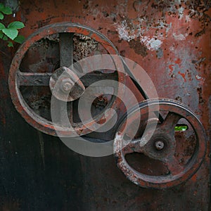 Old Rusty broken metal pulley with belt, machinery gear pulley