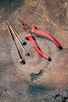 Old rusty broken tools, nails and pliers on a background of rust