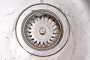 Old rusty calcified drain hole in the kitchen sink with limescale and scurf scum photo