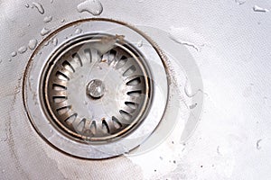 Old rusty calcified drain hole in the kitchen sink with limescale and scurf scum, copy space photo