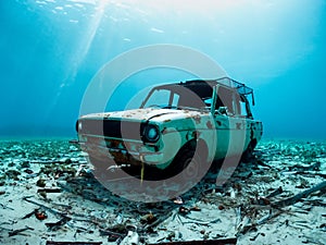 old rusty car with a broken wreck on the beach