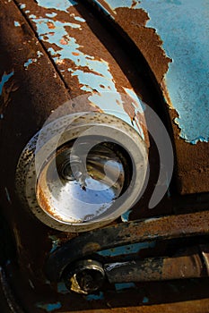 Old, rusty car wreck front and lamp detail