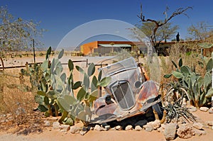 Old and rusty car wreck at the last gas station before the Namib desert. Solitaire, Namibia