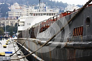 Old rusty cargo ship moored at civil port. . Aged vessel recycling necessity concept