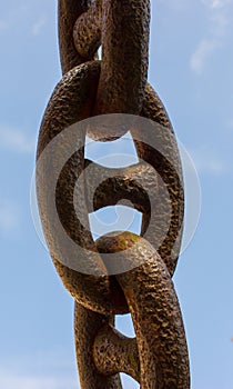 Detail of an old rusty chain on a blue background