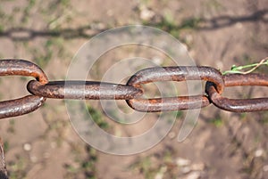 Old rusty chain on the field on the ground background