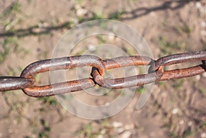 Old rusty chain on the field on the ground background