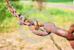 Old rusty chain on the field on the ground background