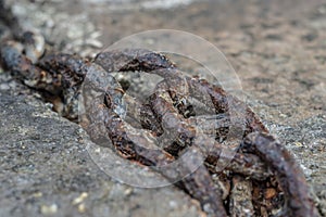 Old rusty chain lying on the stone