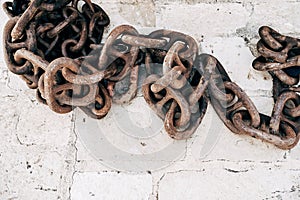 Old rusty chain on a stone background. Several links of a rusty old chain