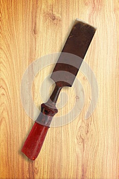Old rusty chisel on wood background