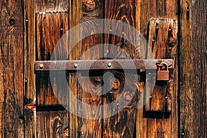 Old rusty corroded padlock on wooden farm barn door