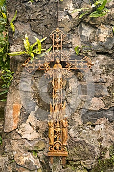 Old rusty crucifix affixed to old stone wall