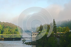 Old rusty dam on a river at cloudy sky