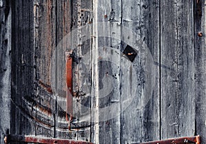 Old rusty deadbolt handle on a weathered wooden door