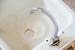 Old rusty dirty faucet on the washstand. There is no hot or cold water in the tap, and the water supply is being