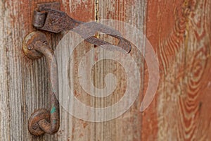 Old rusty door handle and an iron latch in the rust on the wooden doors