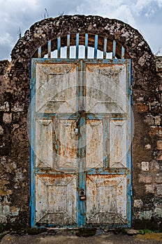 Old rusty door with pad locks and rock arch at historical palace of the Fon, Bafut, Cameroon, Africa