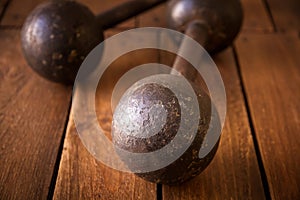 Old rusty dumbbells on wood background texture
