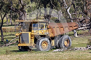 An old rusty earthmoving truck in a green field in regional Australia