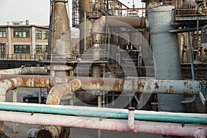 Old rusty factory metal structures with pipes.