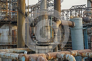 Old rusty factory metal structures with pipes.