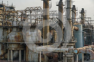 Old rusty factory metal structures with pipes.