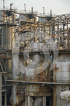 Old rusty factory metal structures with pipes.