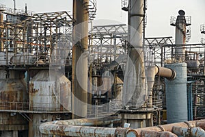 Old rusty factory metal structures with pipes.