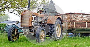 Old rusty farm tractor with trailer